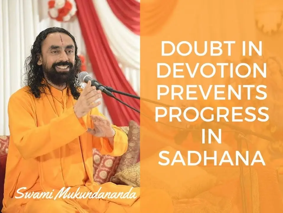 Swami Mukundananda, dressed in a saffron robe, speaks joyfully into a microphone while gesturing with his hands. A quote appears beside him on an orange background: "Doubt in devotion prevents progress in sadhana.