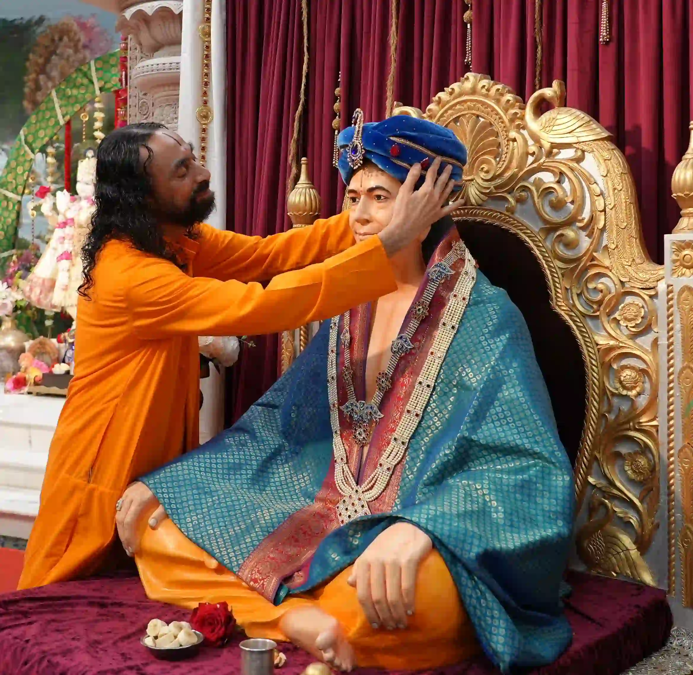 Swami Mukundananda lovingly adorns the deity during a sacred devotional ceremony.