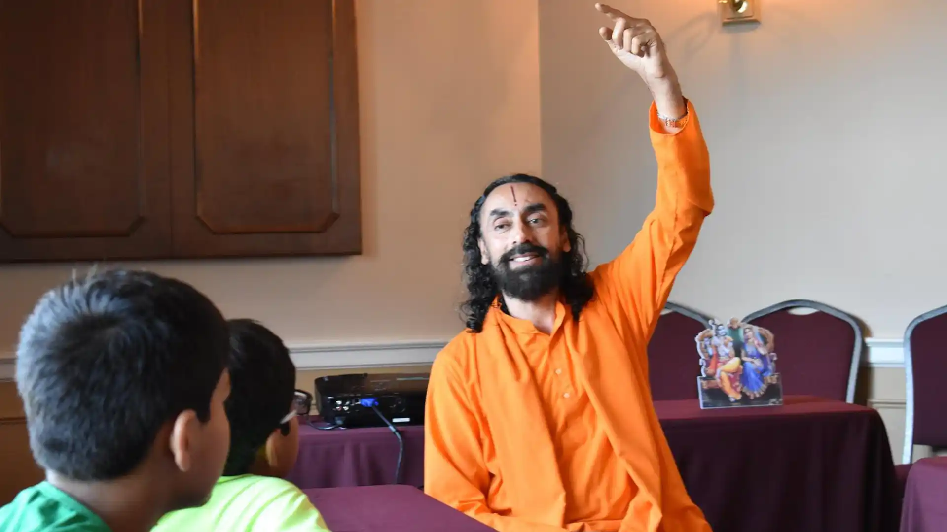 Swami Mukundananda guiding a student through learning, representing expert feedback, encouragement, and accelerated personal growth.