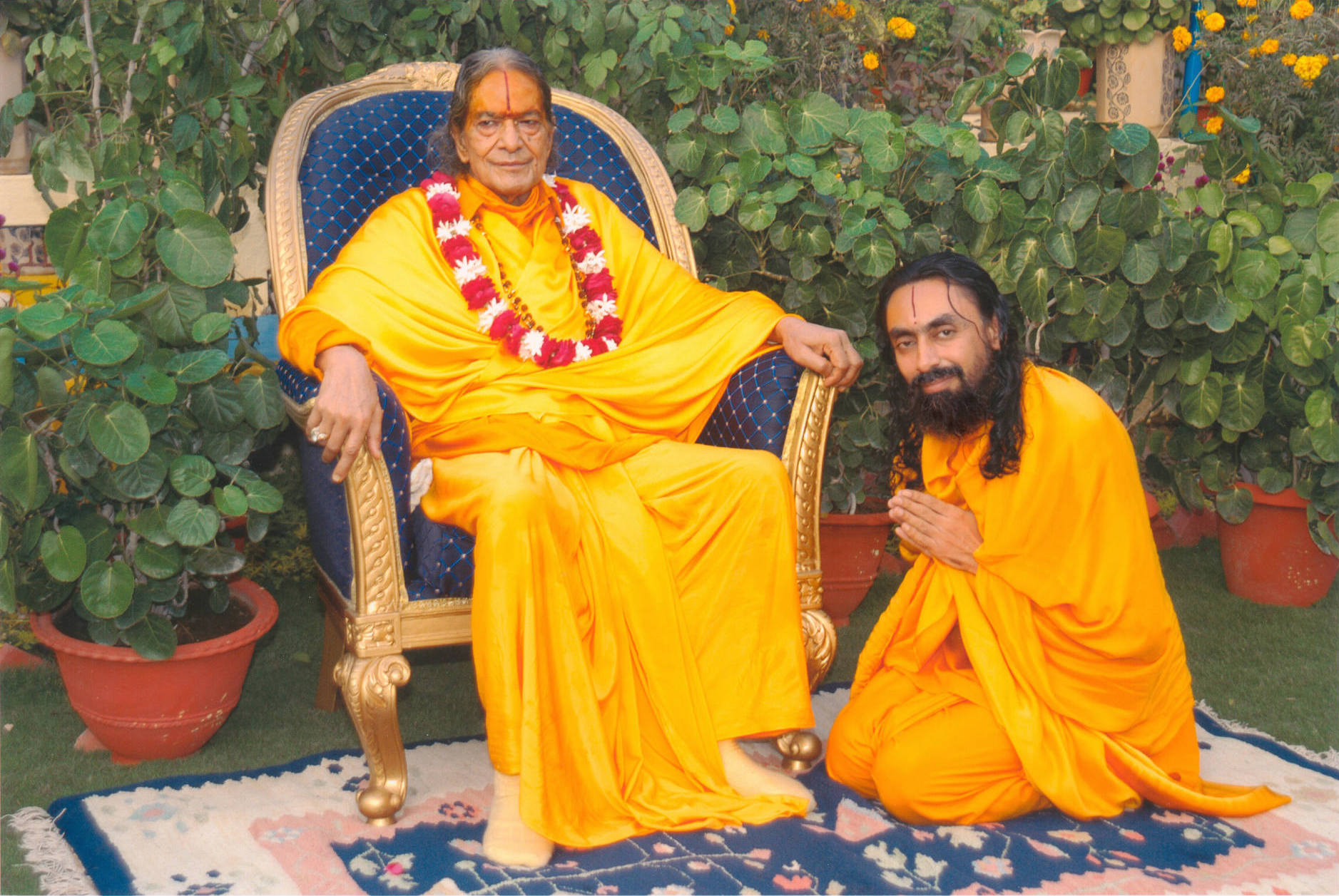 Swami Mukundananda bows respectfully beside his Guru in a peaceful garden setting, symbolizing the transition from worldly mentorship to spiritual guidance, humility, devotion, and inner transformation.