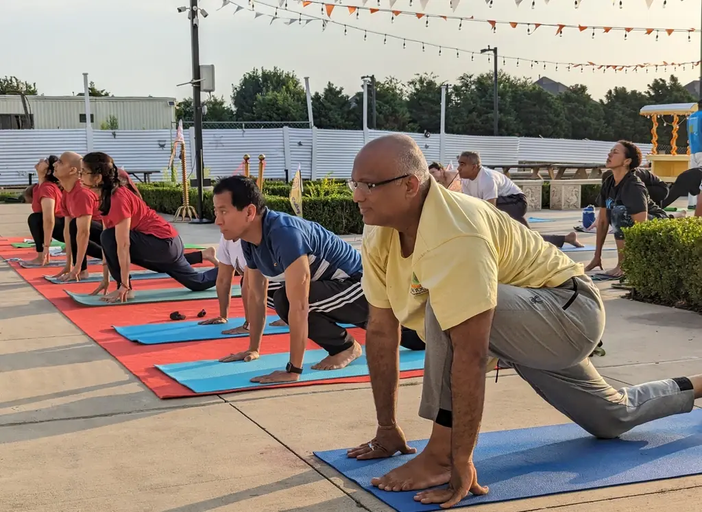 Participants performing 108 Surya Namaskar outdoors at Radha Krishna Temple of Dallas during Dalas Yoga Fest&nbsp; at sunrise.
