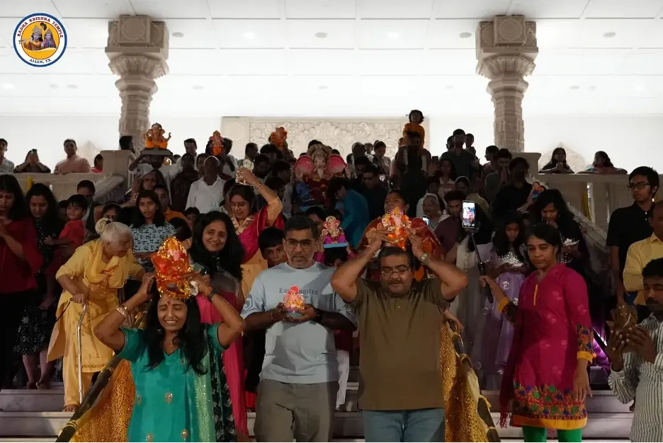 Devotees carrying decorated Ganesh idols inside a temple during Ganesh Chaturthi celebrations